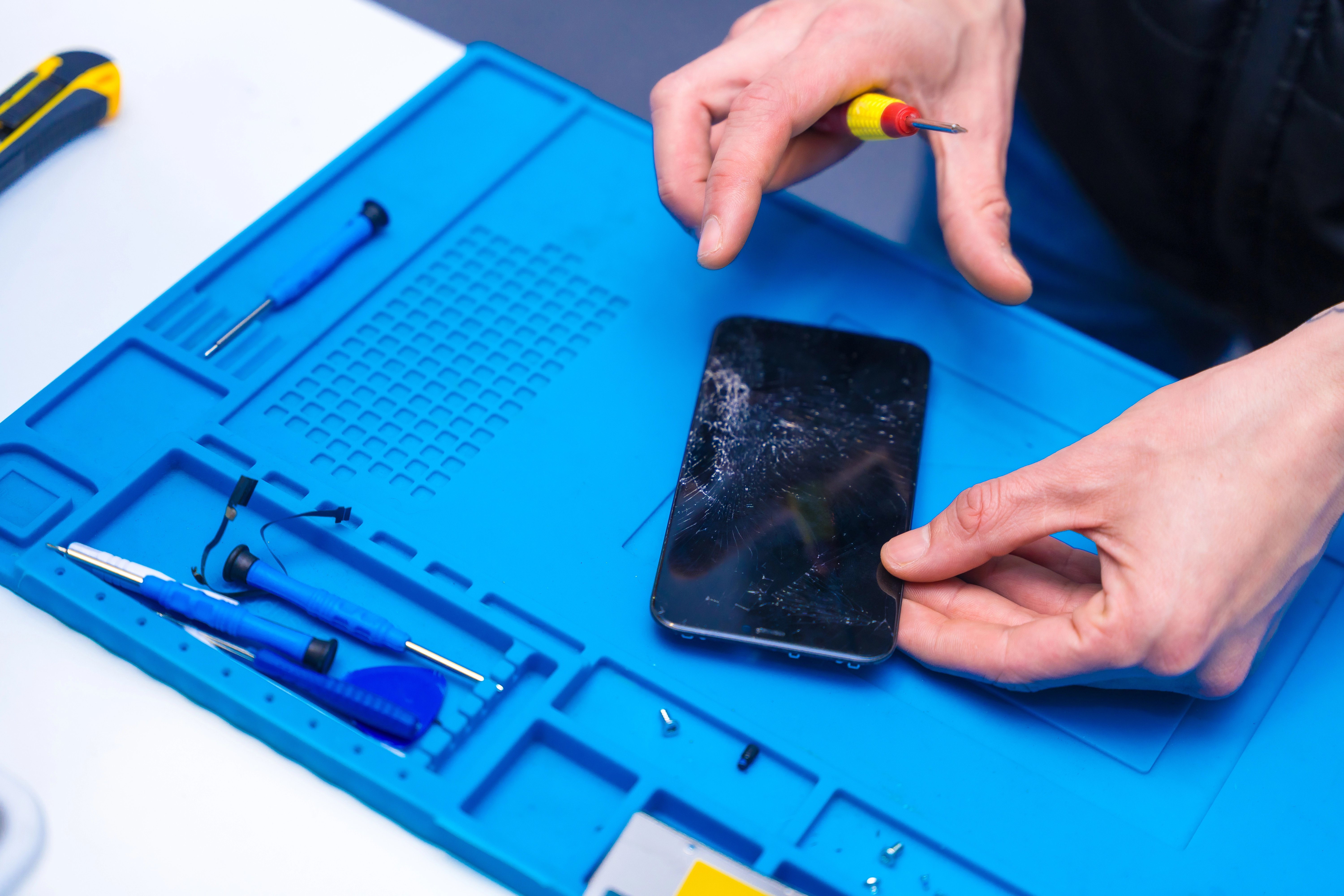 Technicien professionnel EVO MOBILE réparant un écran d'iPhone - Service urgence Paris